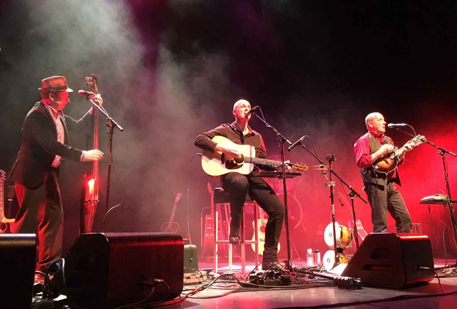 3 mannen op een podium met gitaren en zang