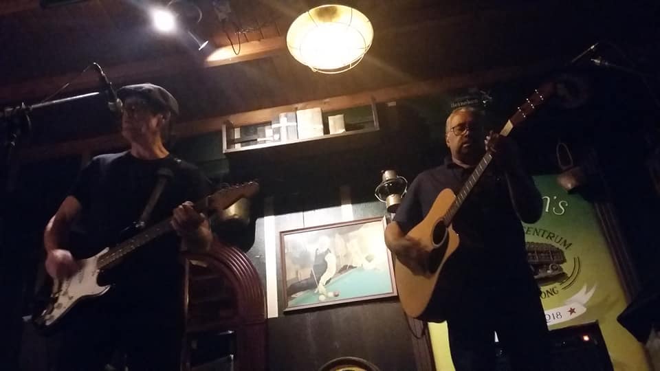 2 mannen op het podium met gitaren in de handen