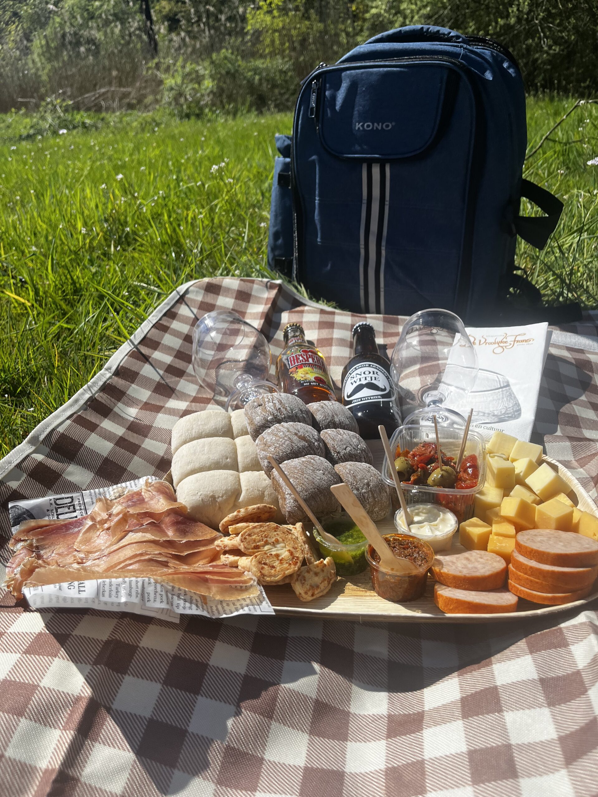 kleedje met lekkere hapjes en drankjes in een weiland met bloemetjes in het zonnetje